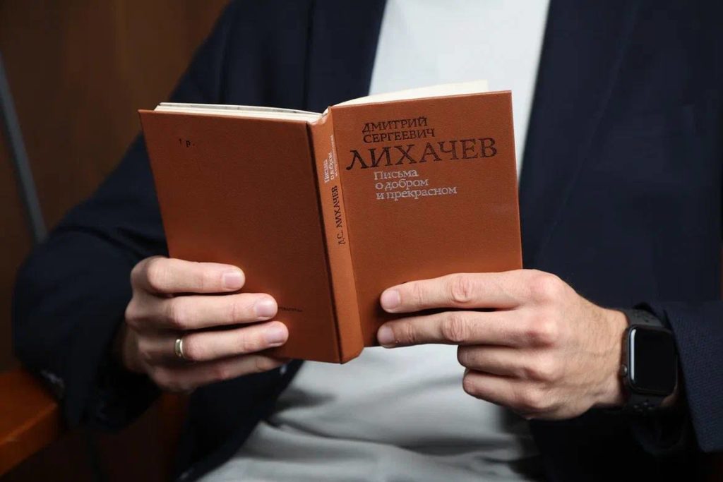 Руки держат книгу Дмитрия Лихачёва «Письма о добром и прекрасном»